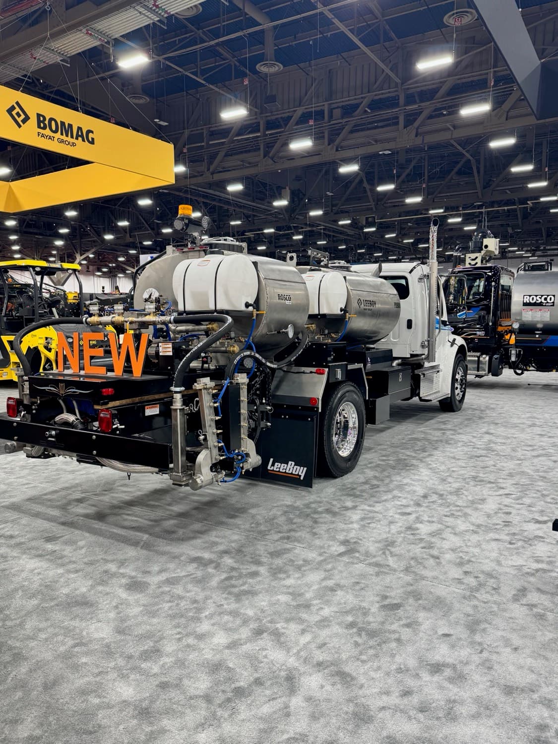Dual-tank distributor with twin stainless tanks on an industry trade show floor